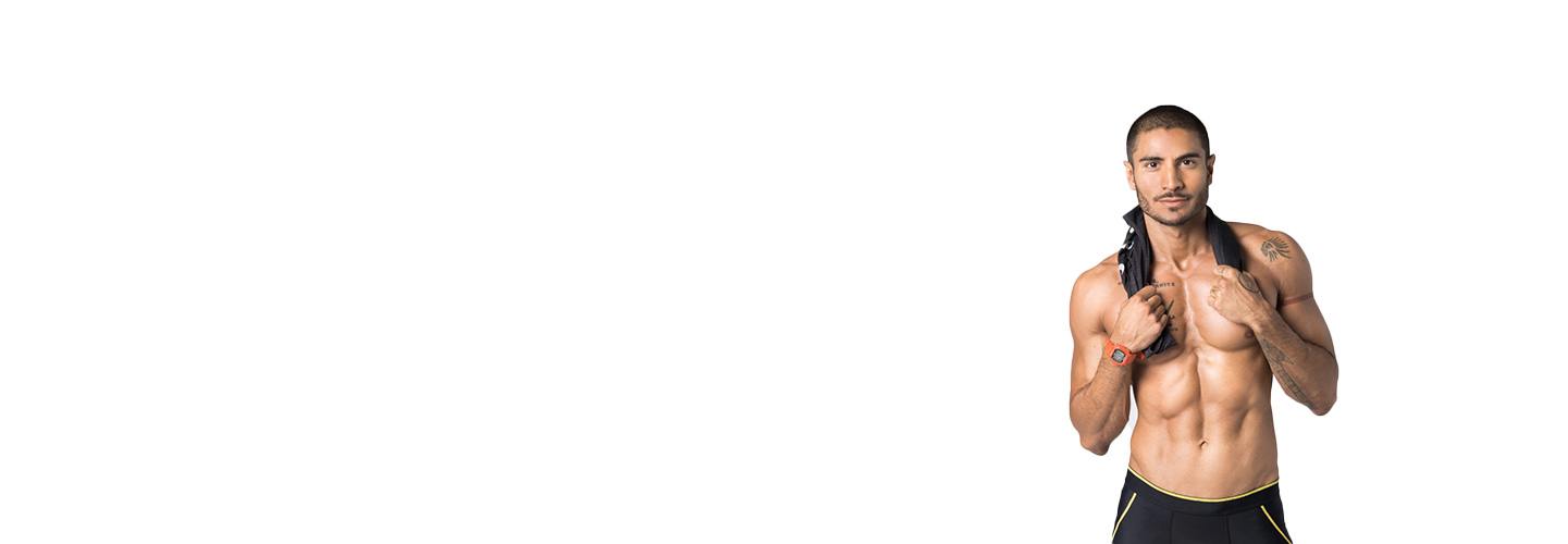 Shirtless Barry's Bootcamp instructor Alex Shirpey smiling on white background