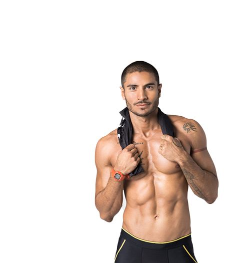 Shirtless Barry's Bootcamp instructor Alex Shirpey smiling on white background