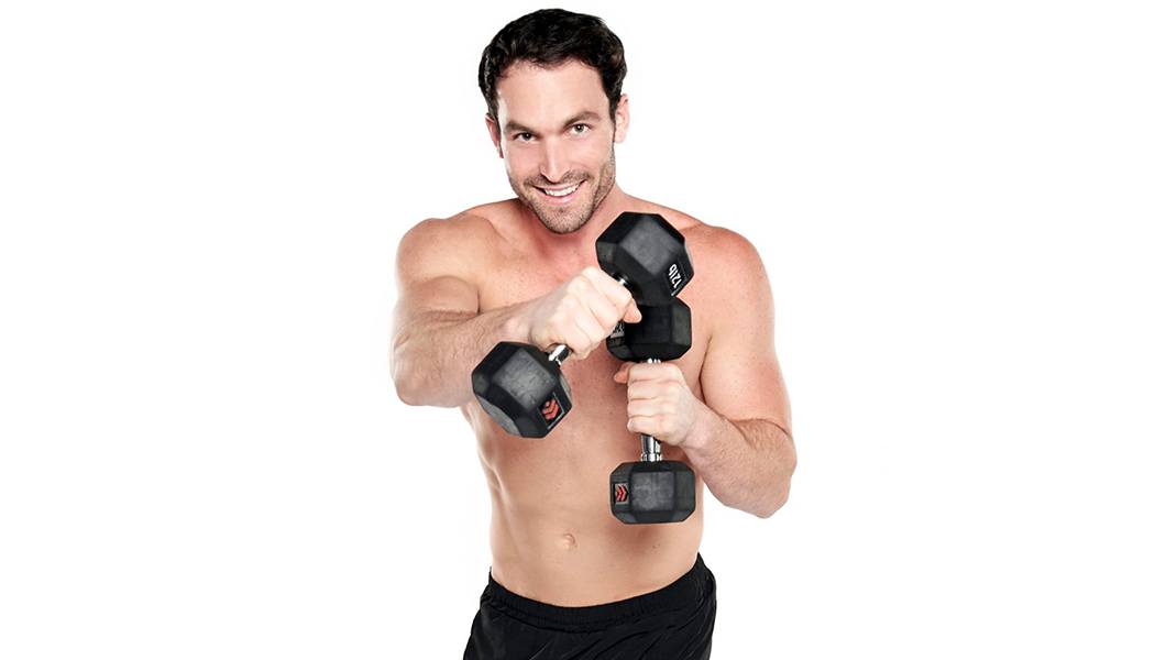Barry's instructor Alex Sapot in shirtless posing with dumbbells
