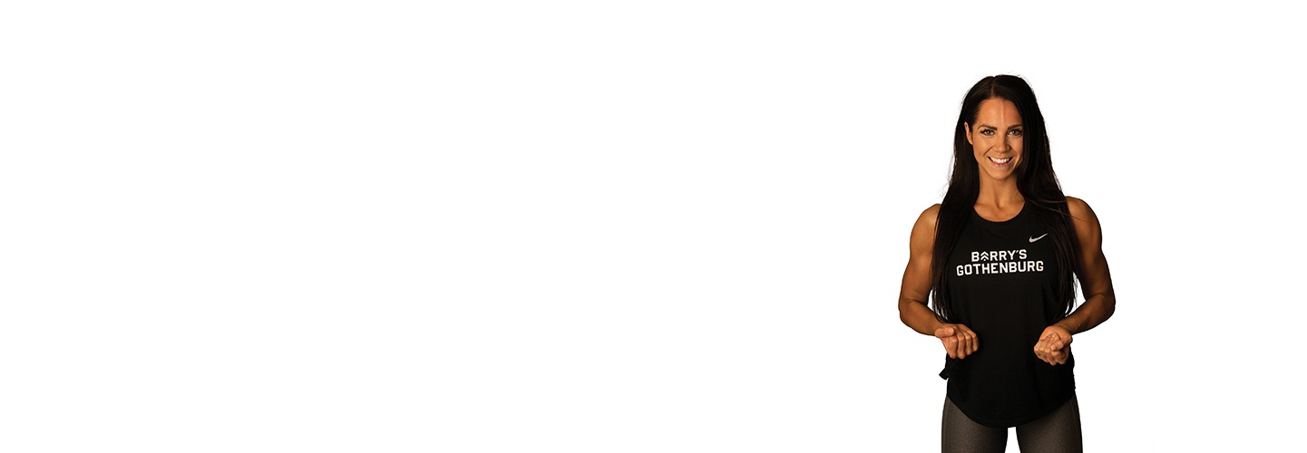 Barry's Bootcamp instructor flexing with closed fists against a white background.