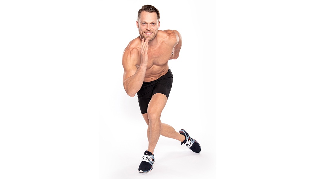 Barry's Instructor Andrew Key shirtless with black shorts in running position.