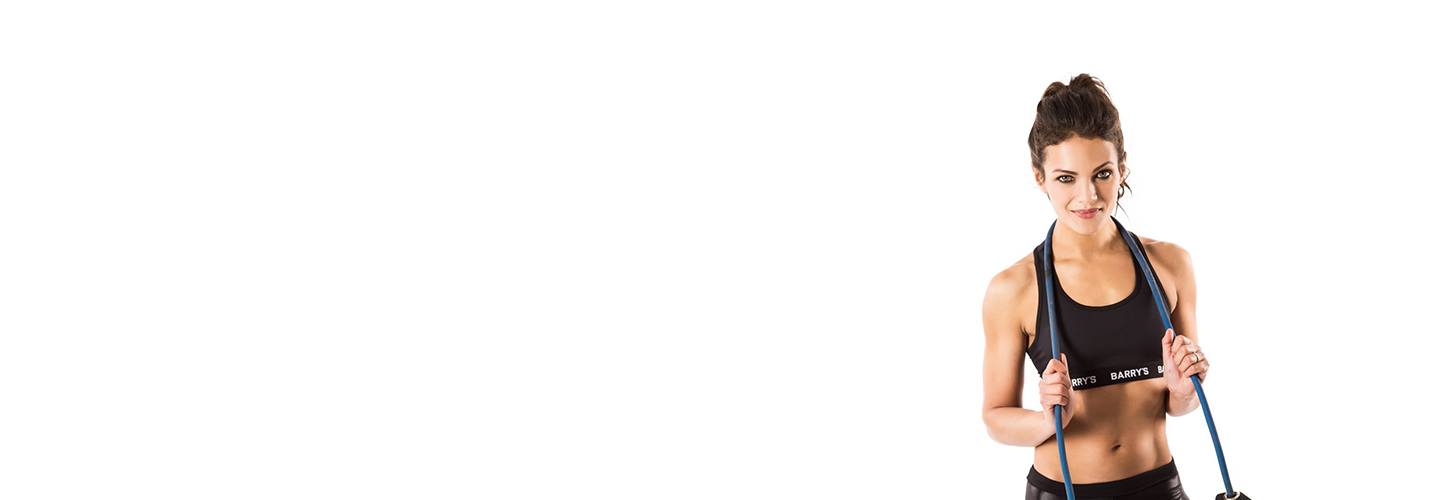 Barry's instructor Anya Lahiri wearing black sports bra posing with jumprope