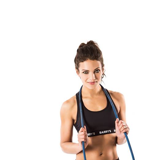 Barry's instructor Anya Lahiri wearing black sports bra posing with jumprope