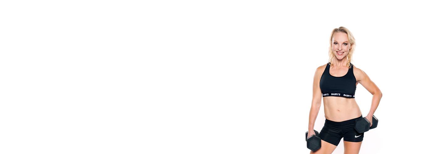 Barry's Instructor Brooke Sheely wearing black sports bra posing with dumbbell