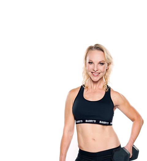 Barry's Instructor Brooke Sheely wearing black sports bra posing with dumbbell