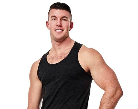 Headshot of Barry's Bootcamp instructor Connor Miller in black tank top smiling with hand on hip