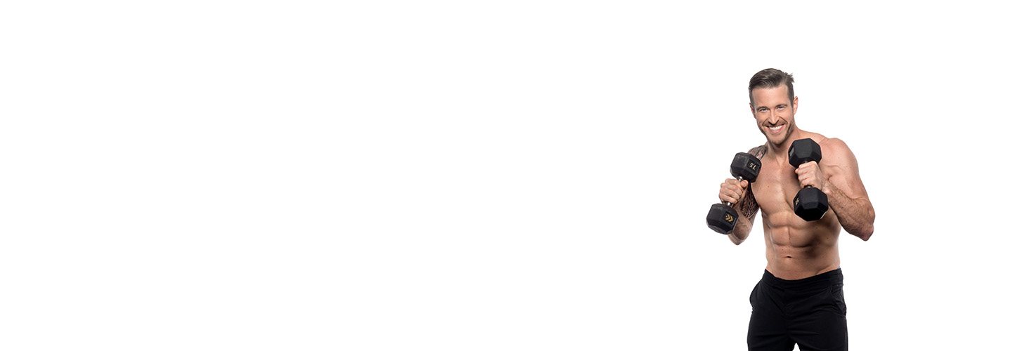 Barry's Bootcamp instructor Dan Cook shirtless holding dumbbells up near his chest.