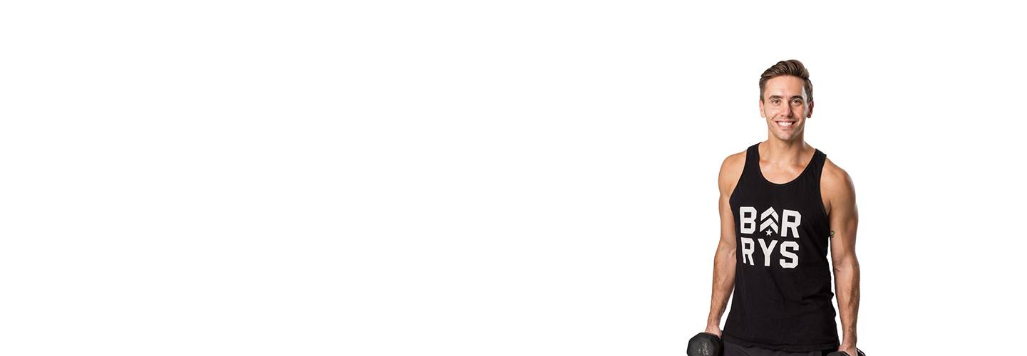 Barry's instructor Derek DeGrazio wearing a black tank top posing with dumbbells