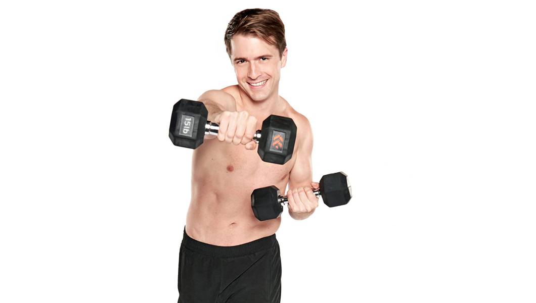 Barry's instructor Erik Steffens shirtless posing with dumbbells