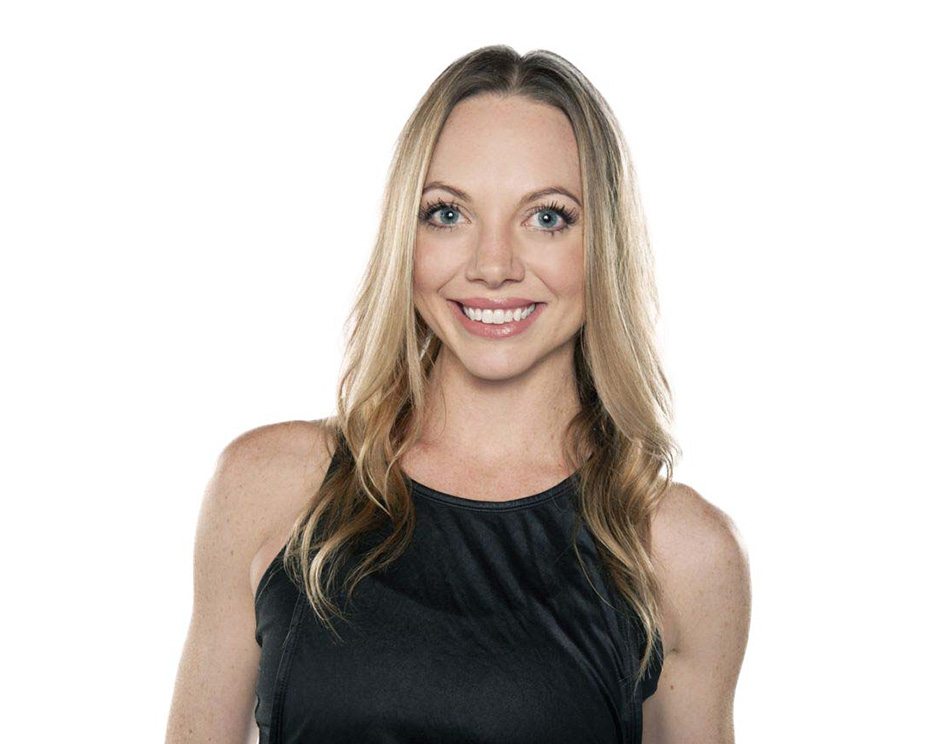 Barry's instructor standing confidently wearing a black tank top against a white background, ready for the next workout challenge.