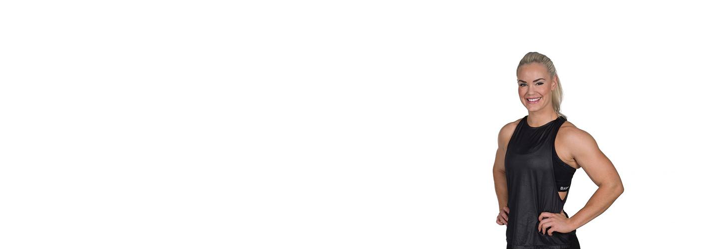 barry's instructor Fam Elgan in black tank posing with hands on hips