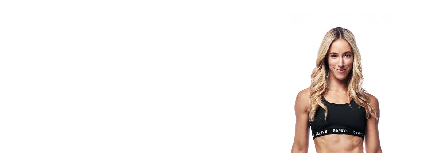 Barry's Bootcamp instructor Hayley Steinberg wearing a black bra against a white background.