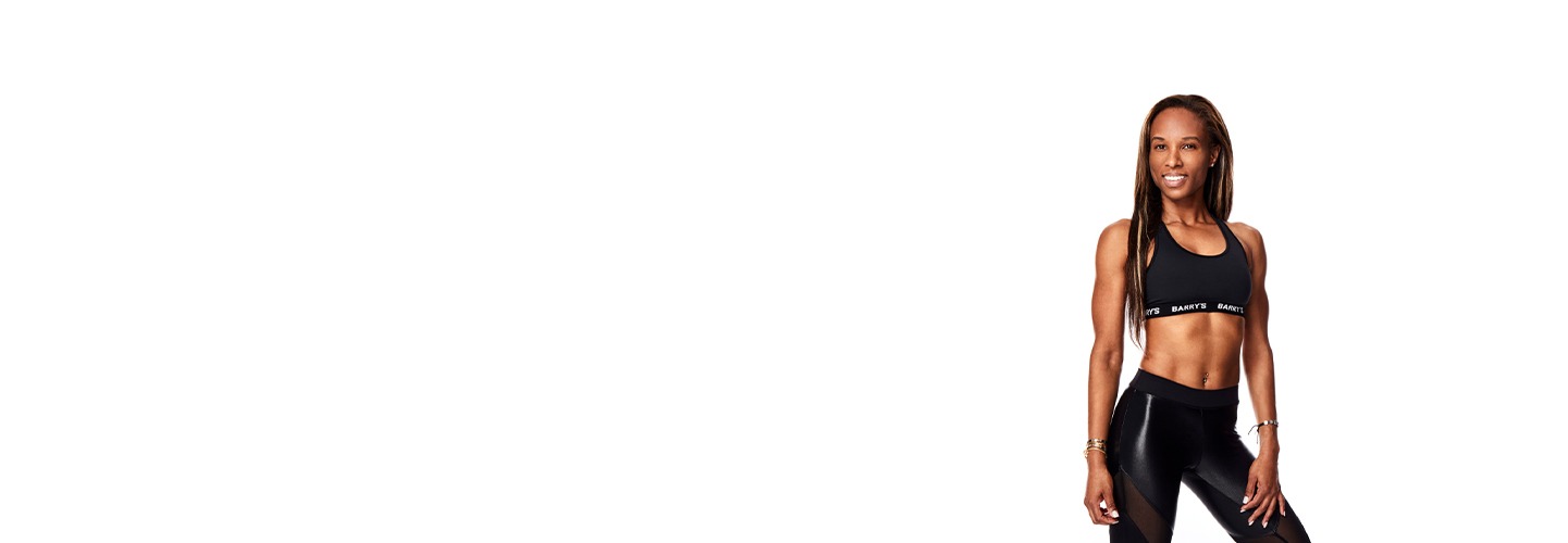 Instructor Janet Koeiman in black Barry's Bootcamp sports bra smiling on white background