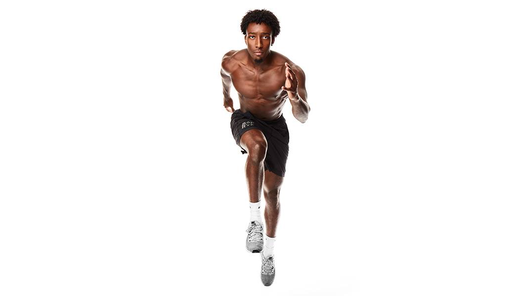 Barry's Bootcamp instructor Joseph Allen shirtless in a running position.