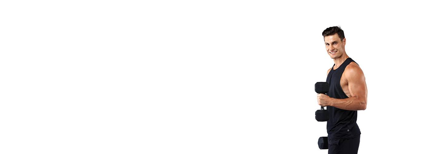 Barry's Bootcamp instructor Joe Nicastro in black tank top smiling while holding dumbbell on white background