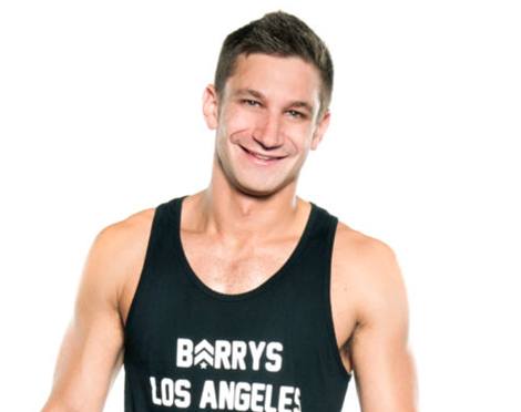 Headshot of instructor Jordan Gluck in black Barry's Bootcamp tank top smiling on white background