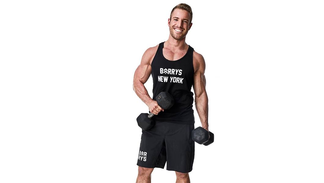 Headshot Barry's instructor Josey Greenwell in black tank posing with dumbbells
