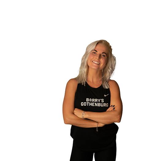 Headshot of Barry's Bootcamp instructor Karoline Pettersson wearing a black Barry's tank top with her arms crossed.