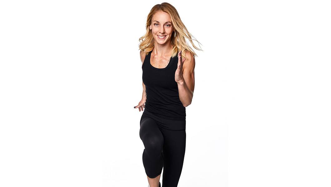 Barry's Bootcamp instructor Kelly Whittaker in black tank in running position.