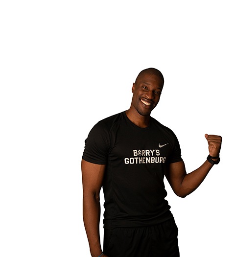 Barry's Bootcamp instructor Kevin Ukhagbe flexing his left bicep against a white background.