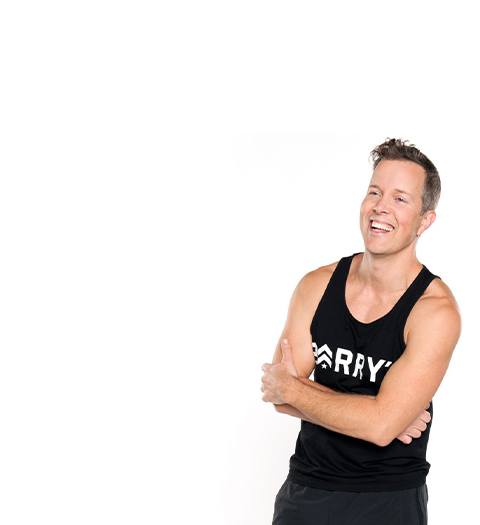 Barry's Instructor Martin George wearing black tank with arms folded