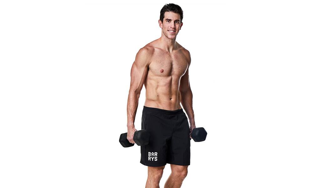 Barry's instructor Matt Nolan shirtless posing with dumbbells
