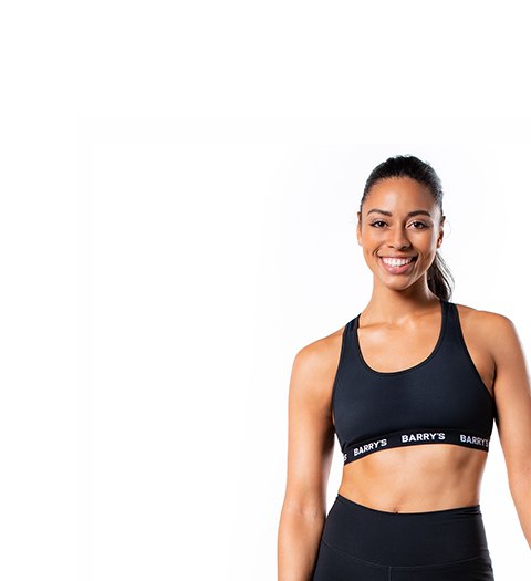 Barry's Bootcamp instructor Mercedes Owens wearing a black sports bra against a white background.