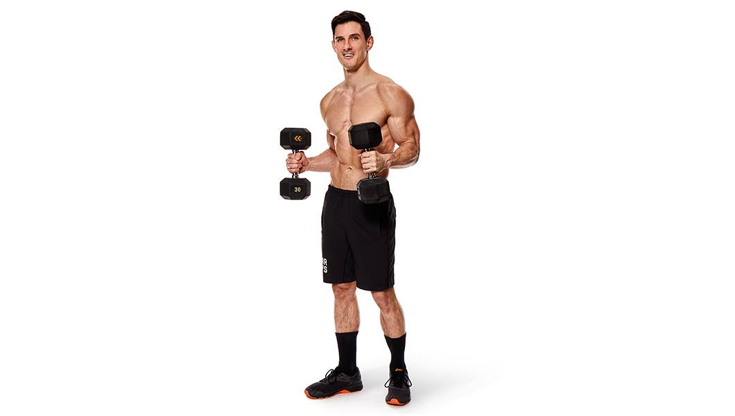 Shirtless Barry's Bootcamp instructor Michael Pugliese holding dumbbells in front of white background