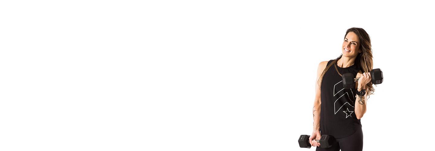 barry's instructor Tee Zitzewitz wearing black tank posing with dumbells