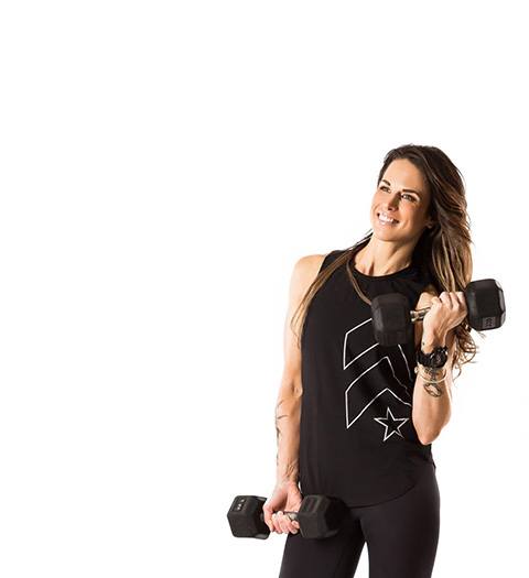 barry's instructor Tee Zitzewitz wearing black tank posing with dumbells