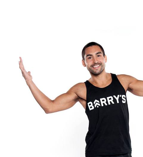 Barry's Instructor Vince Zager wearing black Barry's tank with raised arms