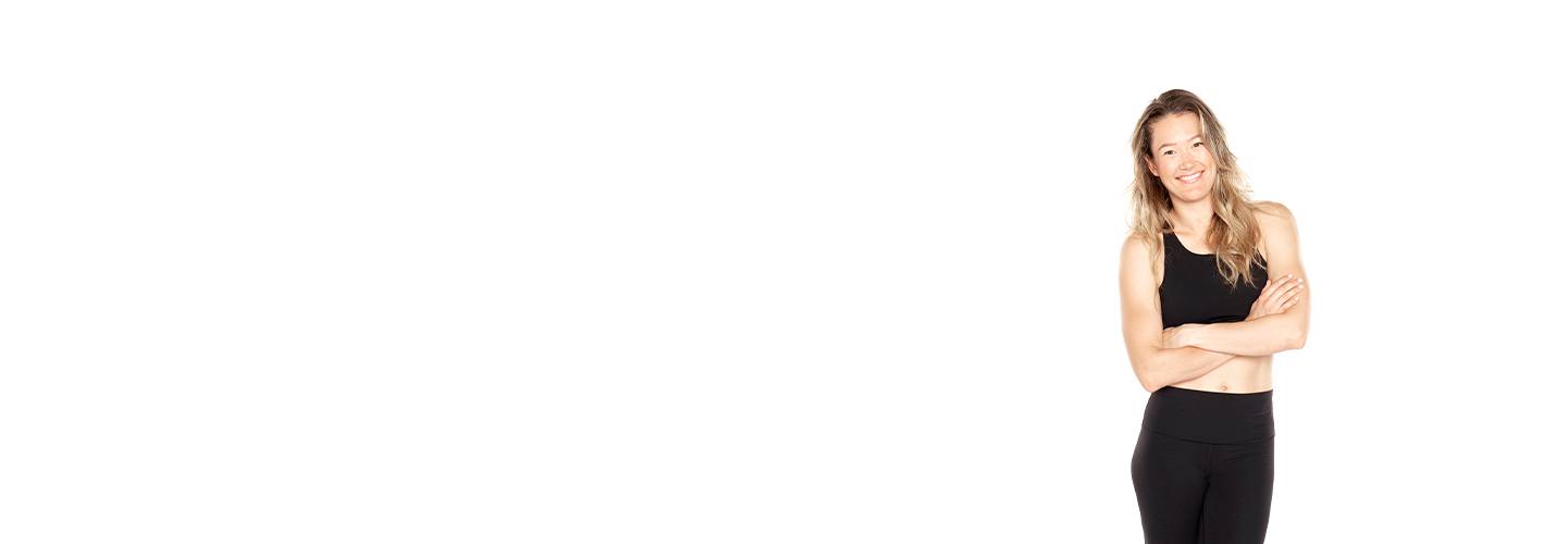 Barry's Bootcamp instructor Georgia Fitzgerald crossing her arms and wearing a black sports bra against a white background.