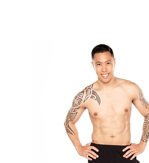 Barry's Bootcamp instructor Matt Marquez shirtless against a white background with his hands on his hips.