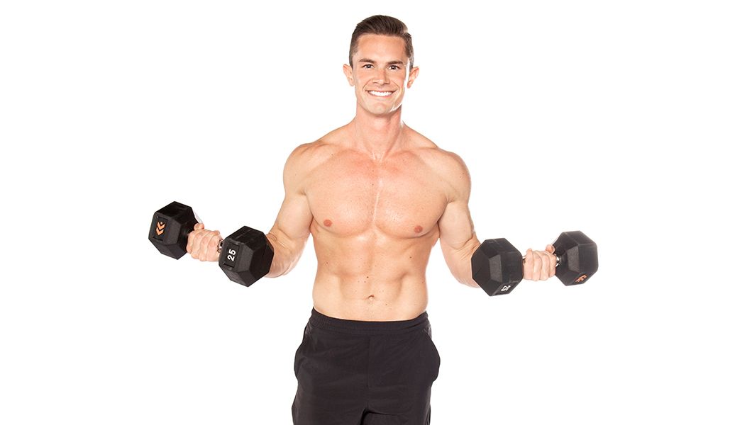 Barry's instructor standing confidently shirtless with weights out to the side against a white background, ready for the next workout challenge.