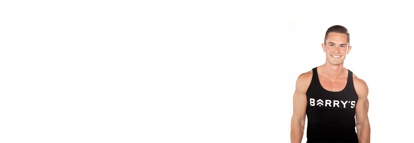 Barry's instructor standing confidently wearing a black tank top against a white background, ready for the next workout challenge.