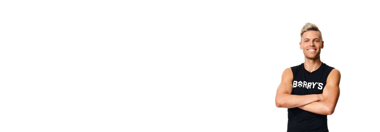 Instructor Zac Hope smiling in Barry's Bootcamp tank top on white background