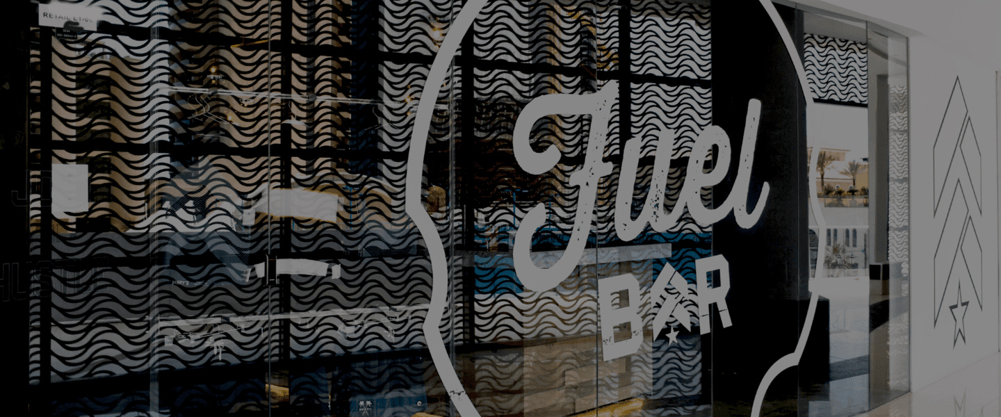 Fuel Bar logo on glass window next to Barry's Bootcamp upward arrow logo