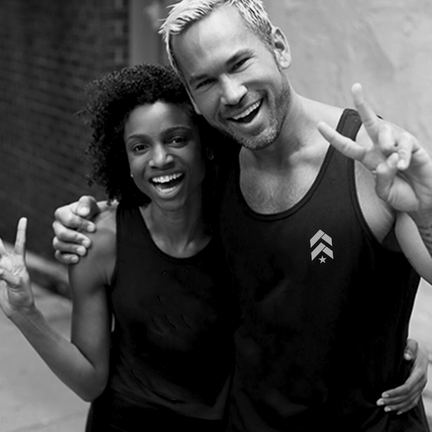 Male and female Barry's Bootcamp instructors posing together and smiling