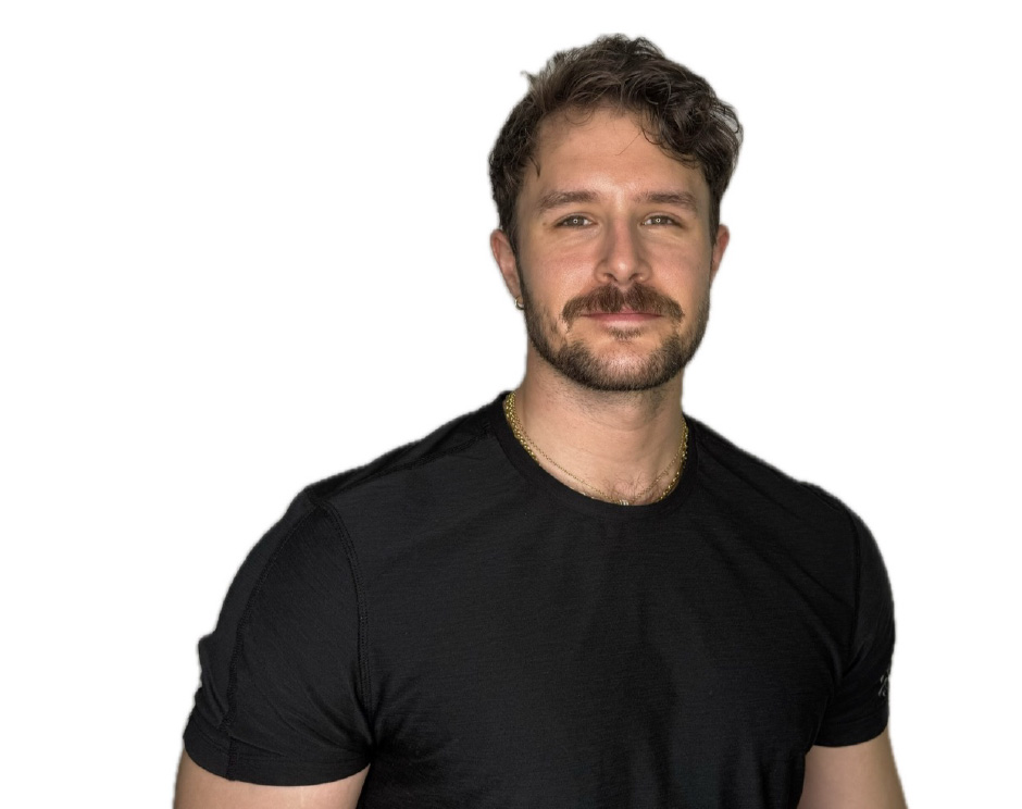 Barry’s instructor wearing a black top standing confidently smiling against a white background