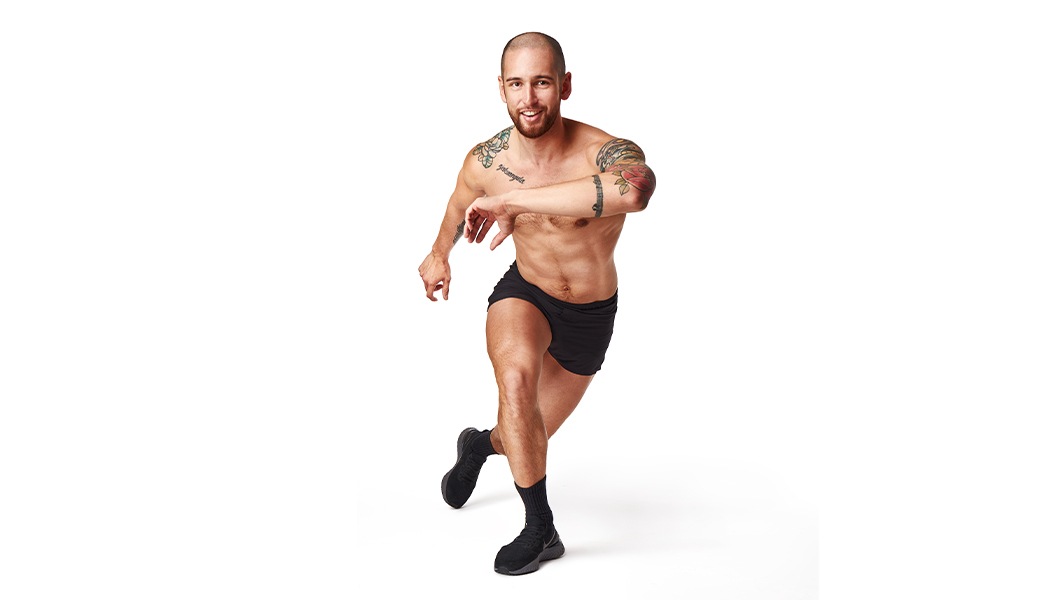 Barry’s instructor shirtless in a lunge smiling against a white background