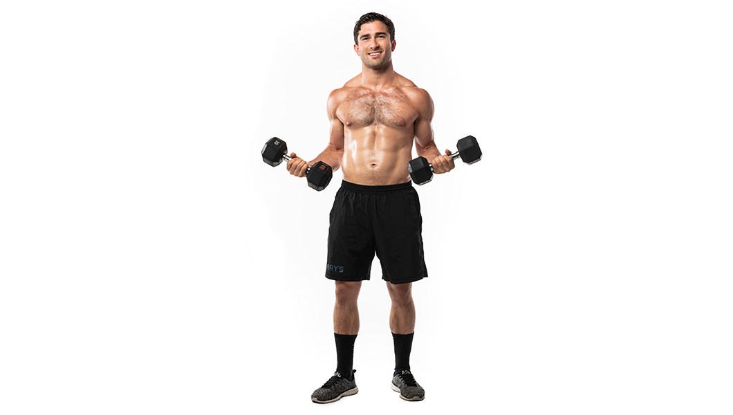 Barry's instructor shirtless standing confidently holding weights out to the side against a white background.