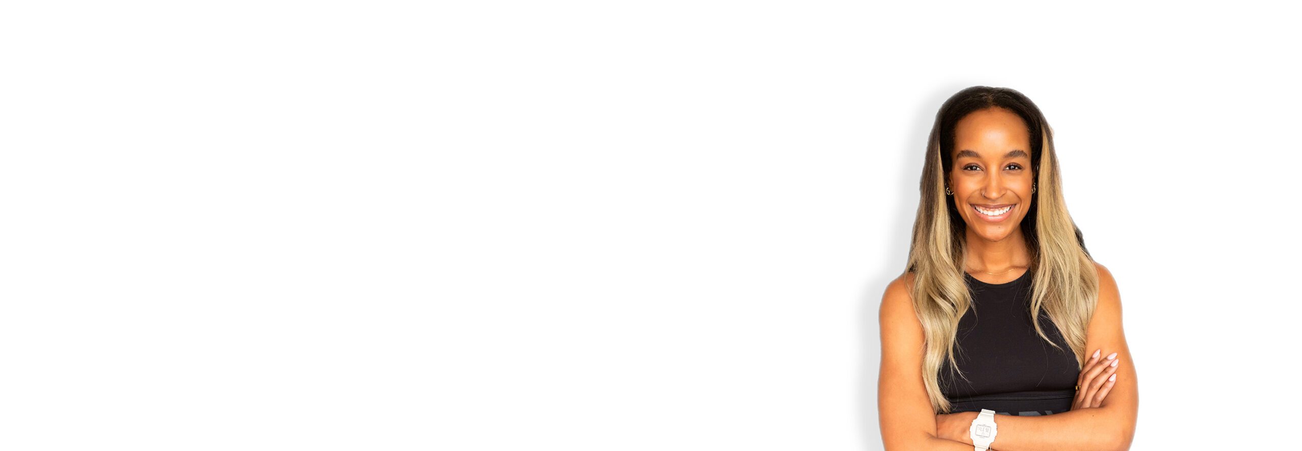 Barry’s instructor wearing a black top standing confidently smiling against a white background