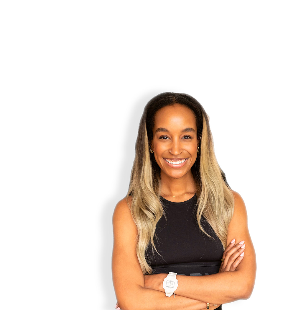 Barry’s instructor wearing a black top standing confidently smiling against a white background