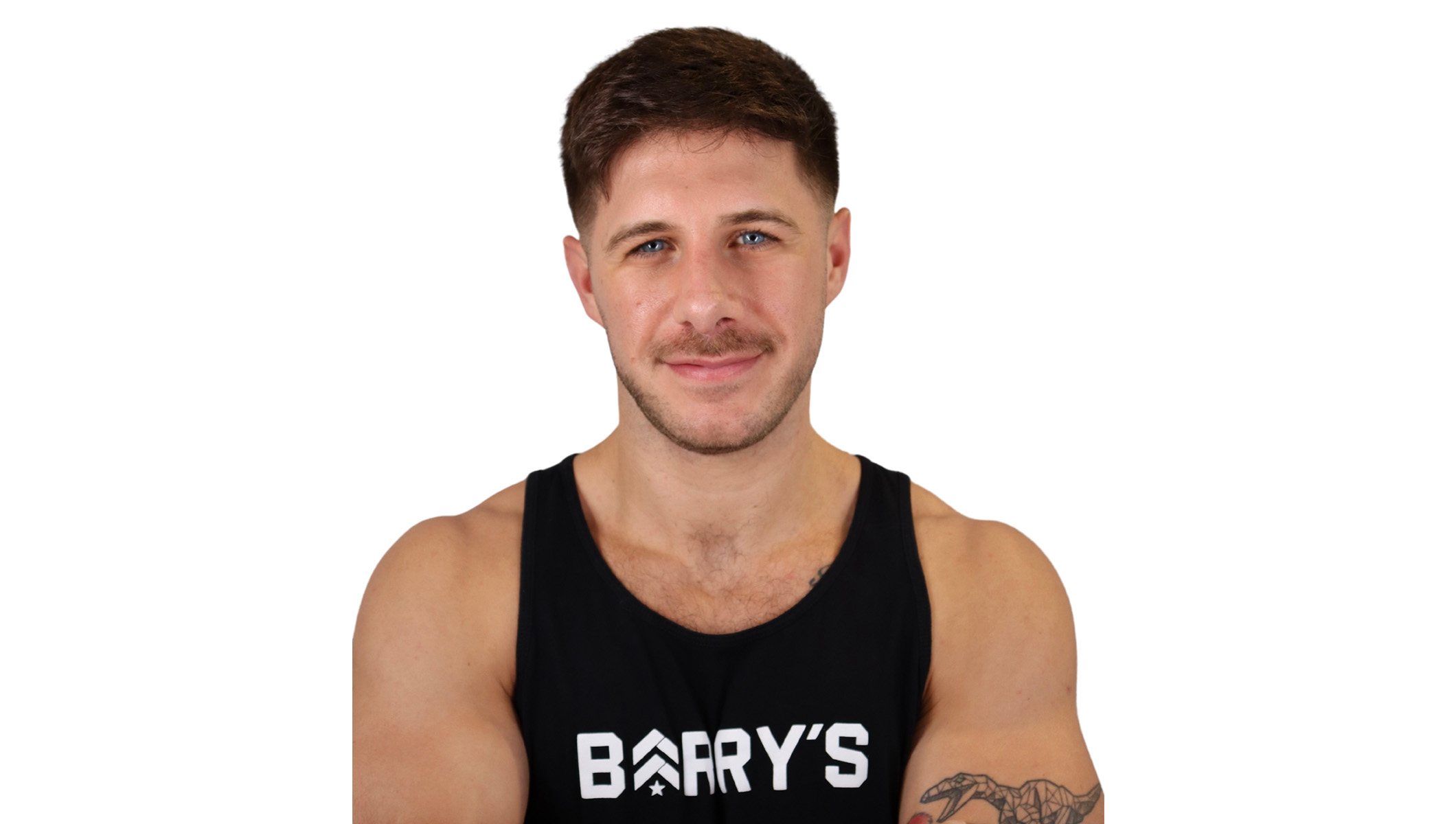 Barry’s instructor wearing a black top standing confidently smiling against a white background
