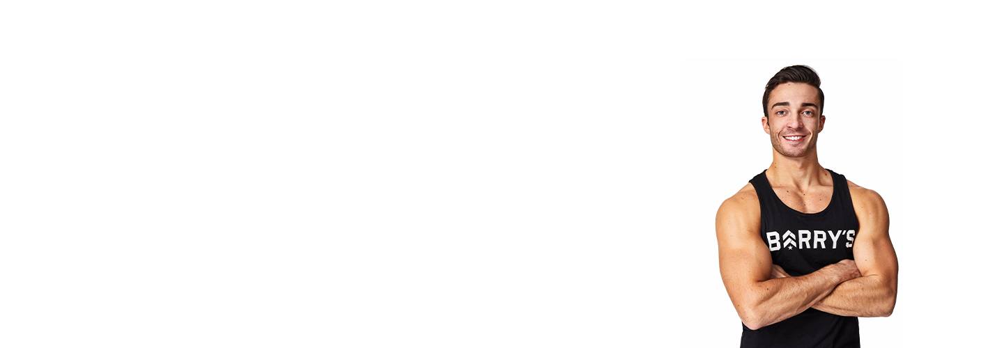 Barry’s instructor wearing a black top standing confidently smiling against a white background