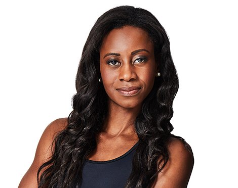 Barry’s instructor wearing a black top standing confidently smiling against a white background