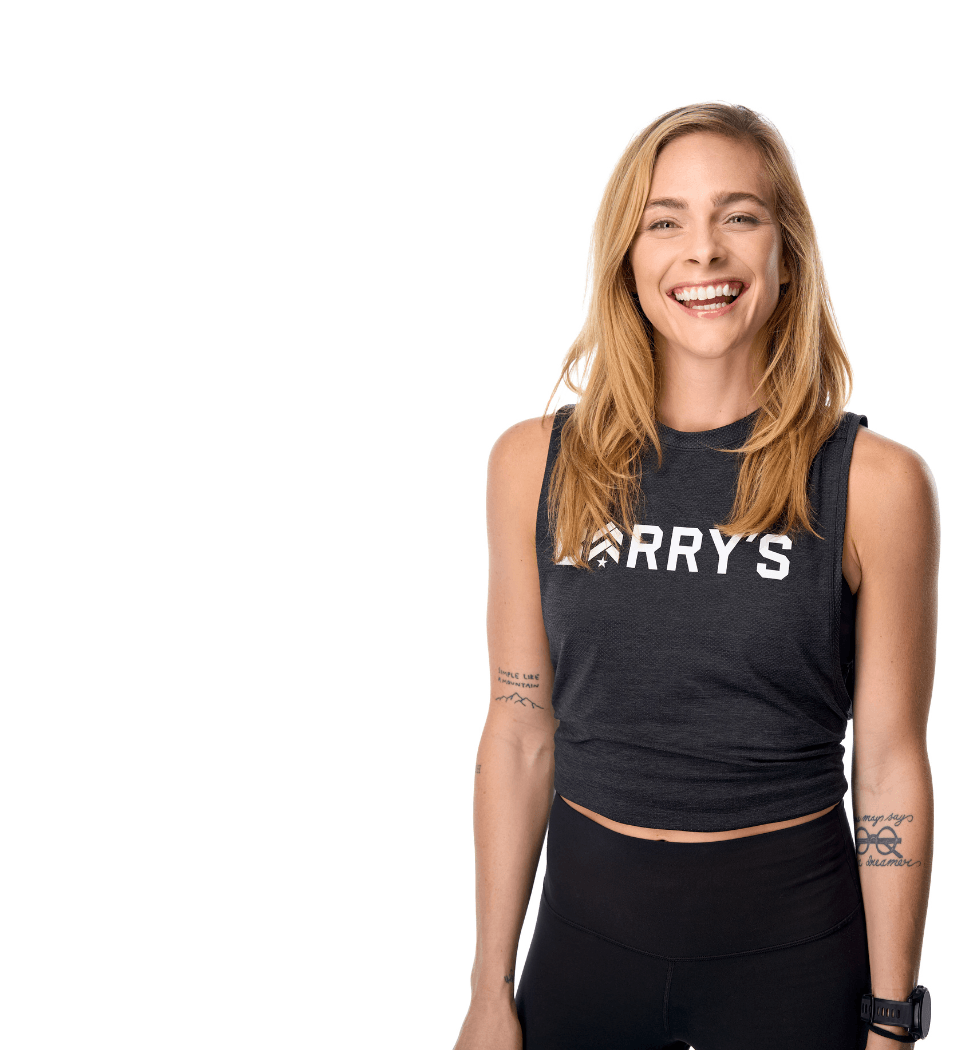 Barry’s instructor wearing a black top standing confidently smiling against a white background