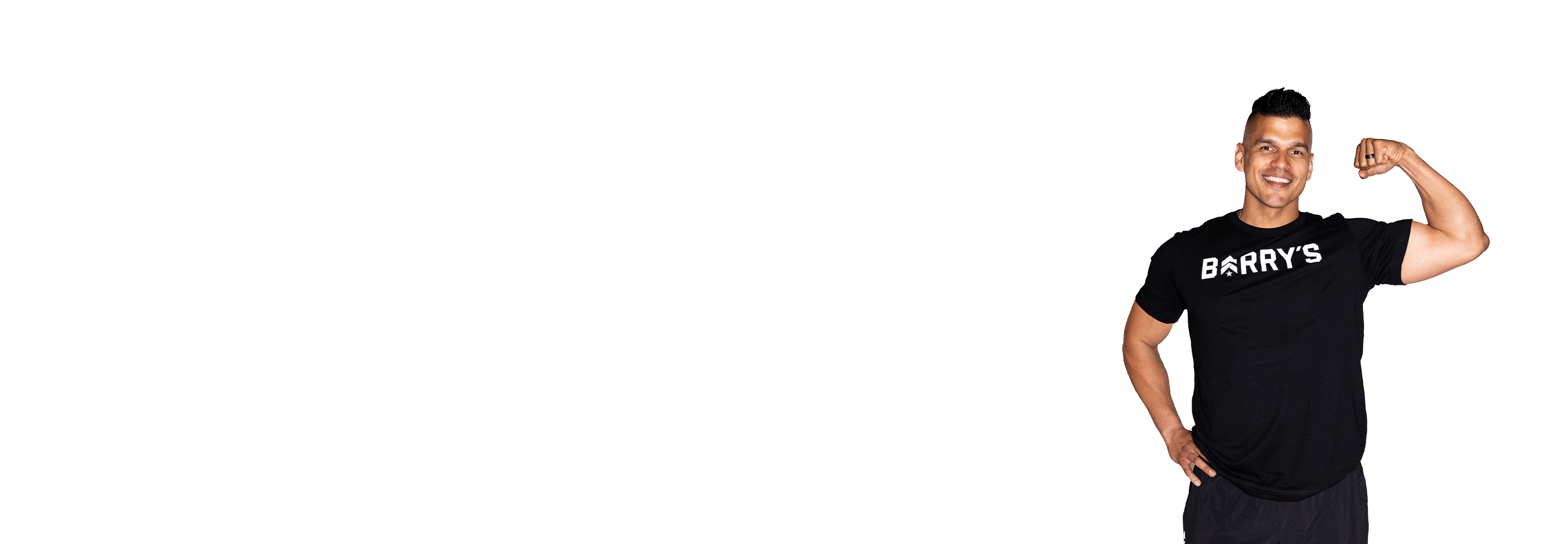 Barry’s instructor wearing a black top standing confidently smiling against a white background