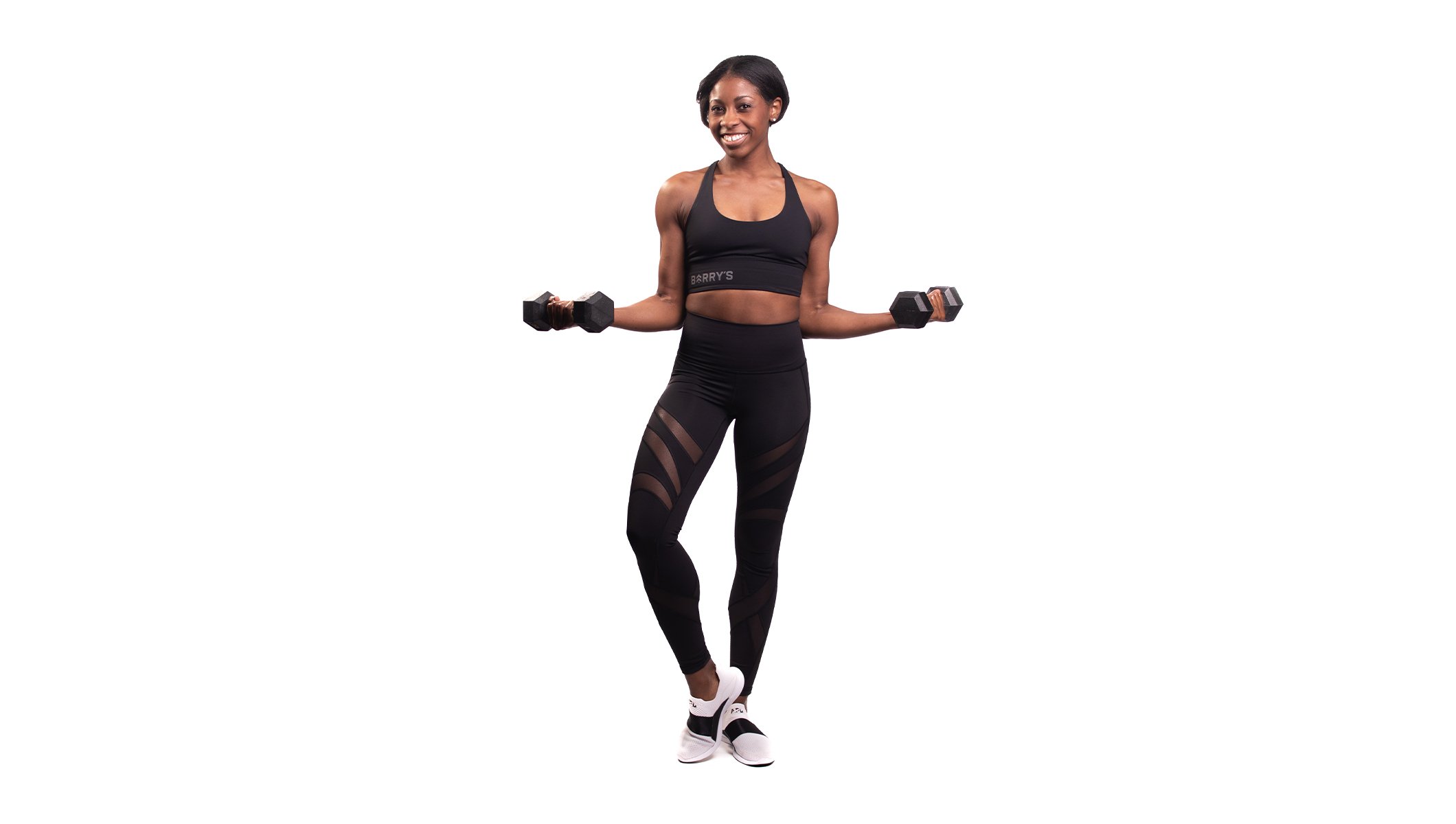 Barry's instructor standing confidently with weights out to the side wearing a black top against a white background.