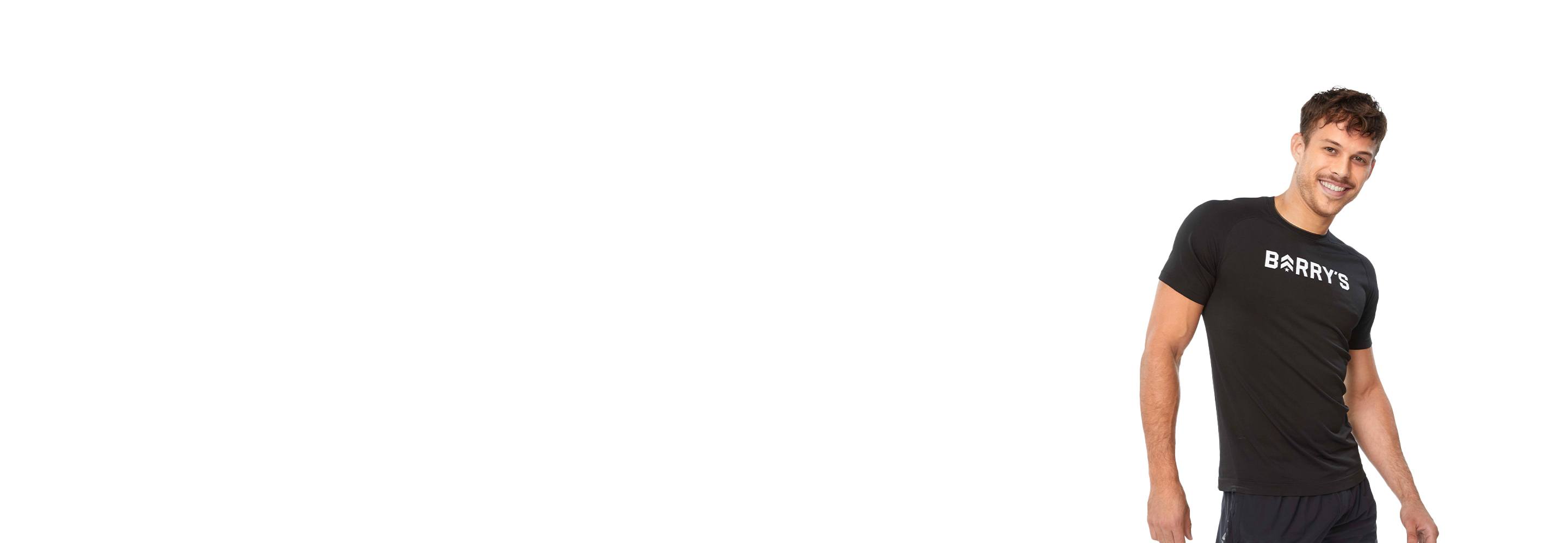 Barry's instructor standing confidently, wearing a black top against a white background, ready for the next workout challenge.